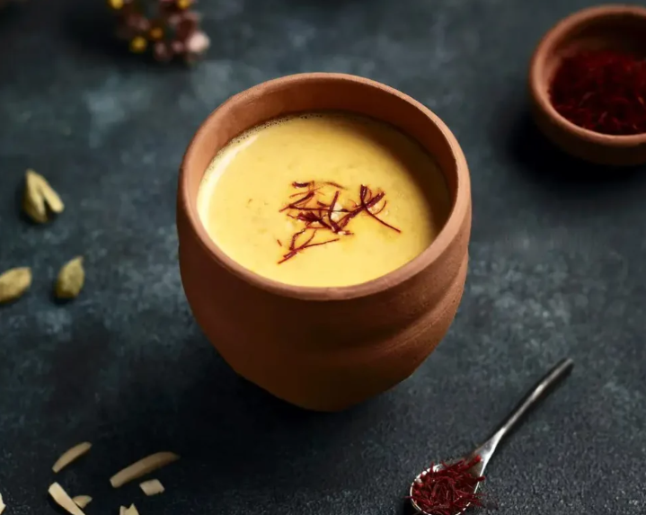 Golden saffron latte in a brown cup with saffron threads