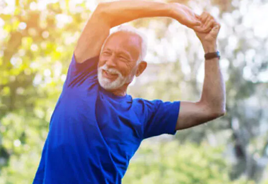 Older man stretching outdoors in a park