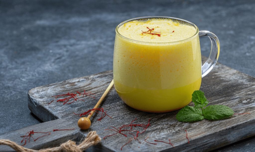 Warm golden saffron milk in a ceramic cup