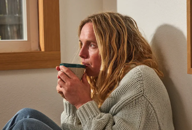 Safran gegen Stress – Frau entspannt sich mit einer Tasse Safrantee zuhause