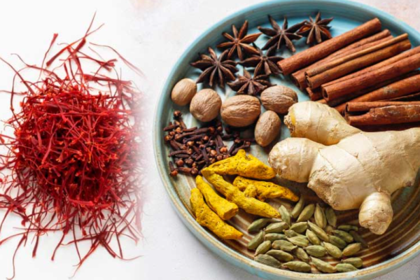 Safran Milch mit Gewürzen in einer Tasse, goldgelbe Farbe mit Safranfäden, Zimtstange und Kardamom als wärmendes Wintergetränk.